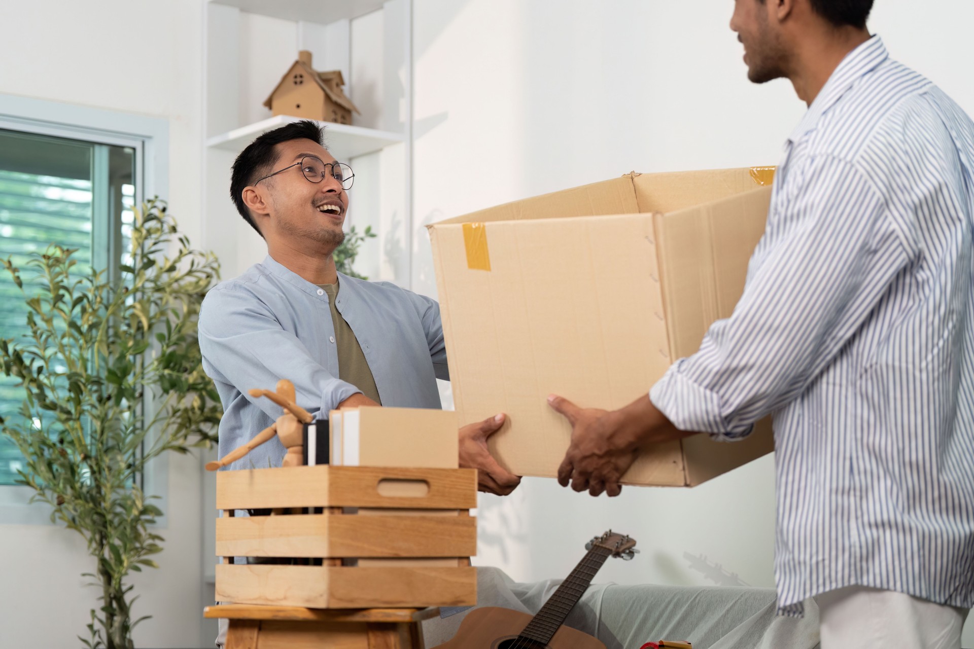 Happy gay couple sharing a moment while moving into their new home