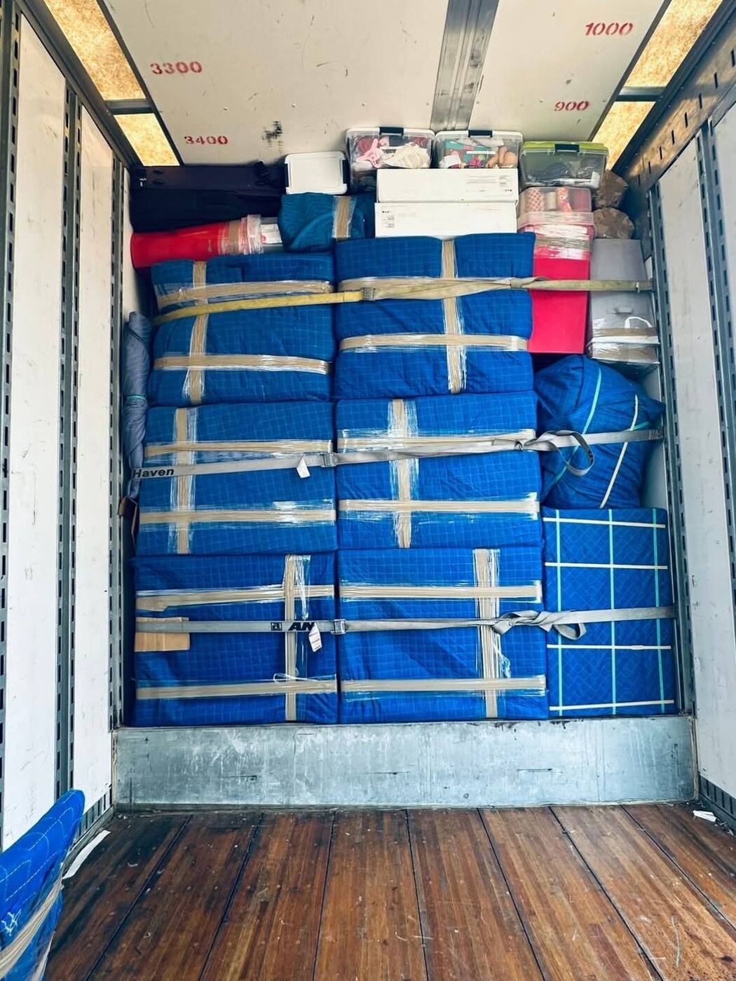 Moving truck fully loaded wall-to-wall with blue moving blanket-wrapped furniture — One World Van Lines DFW Texas movers