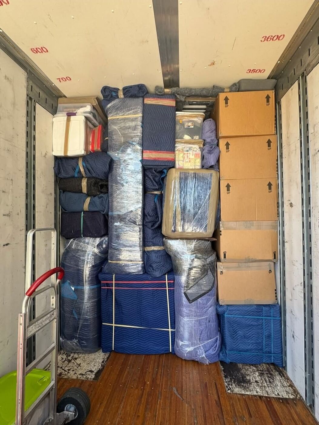 Fully packed moving truck with blue blankets, plastic-wrapped items, and stacked boxes — One World Van Lines Dallas, TX residential move