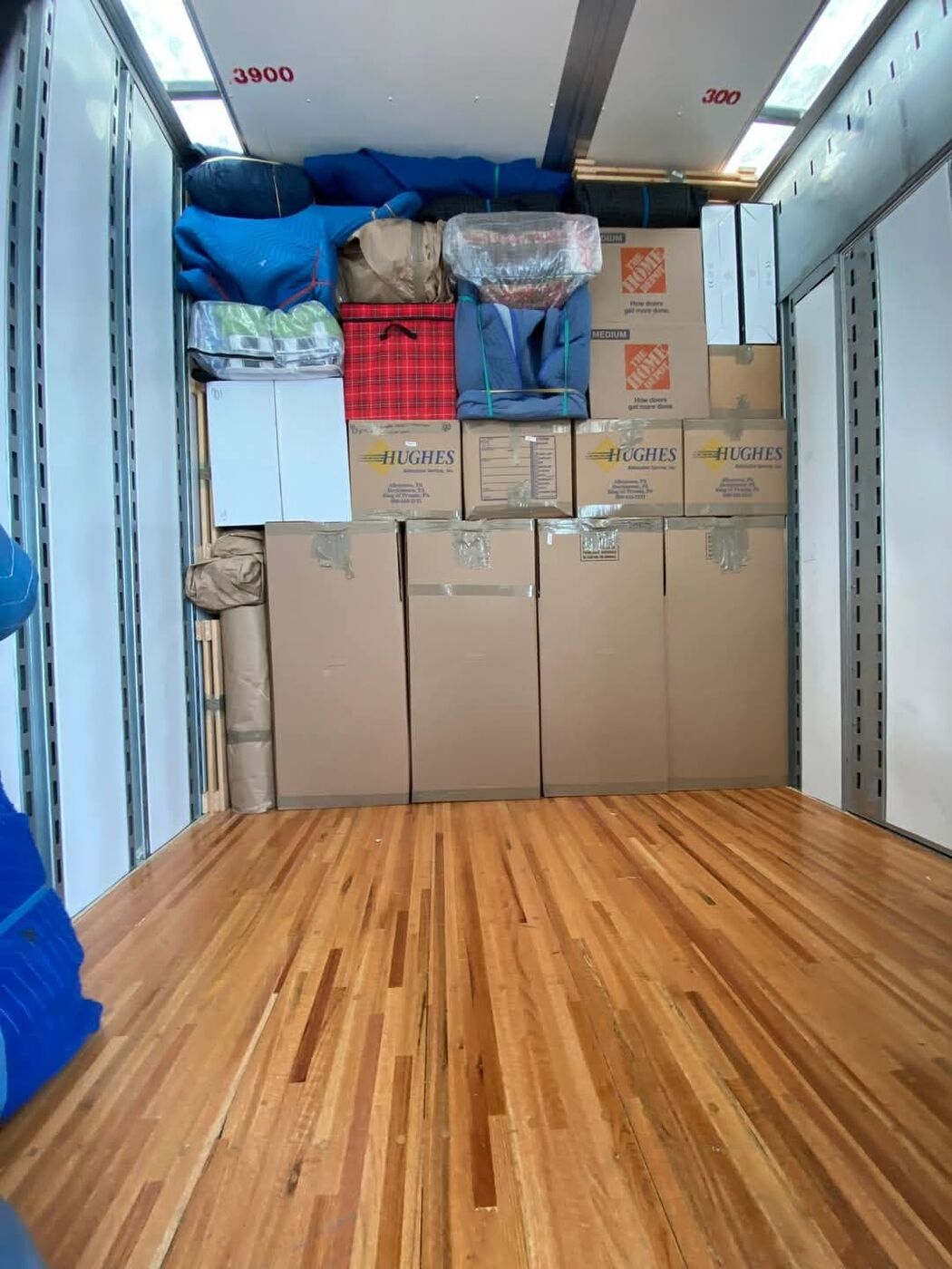 Partially loaded moving truck with wardrobe boxes, Home Depot medium boxes and blue blankets — One World Van Lines Mesquite, TX DFW area movers