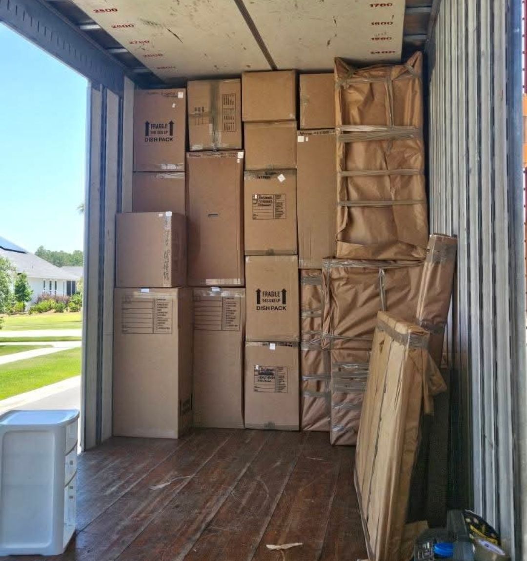 Dish-pack and fragile boxes stacked in moving truck at a residential home — Dallas, TX